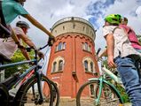 Familie mit Fahrrädern im Sommer vor der Camera Obscura Mülheim