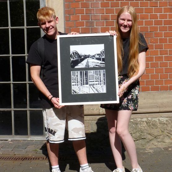 Schüler und Schülerin der Realschule Broich mit einem Bild ihrer Ausstellung „Strukturen” 2022 in der Camera Obscura